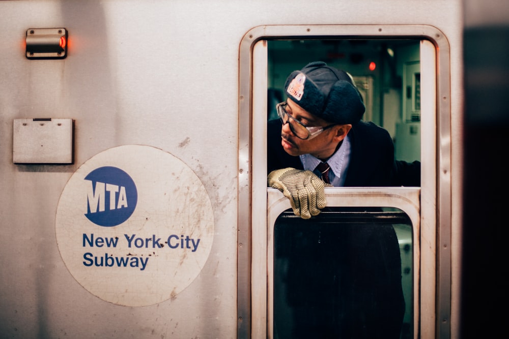 Mann schaut auf das Fenster des New Yorker U-Bahn-Zuges