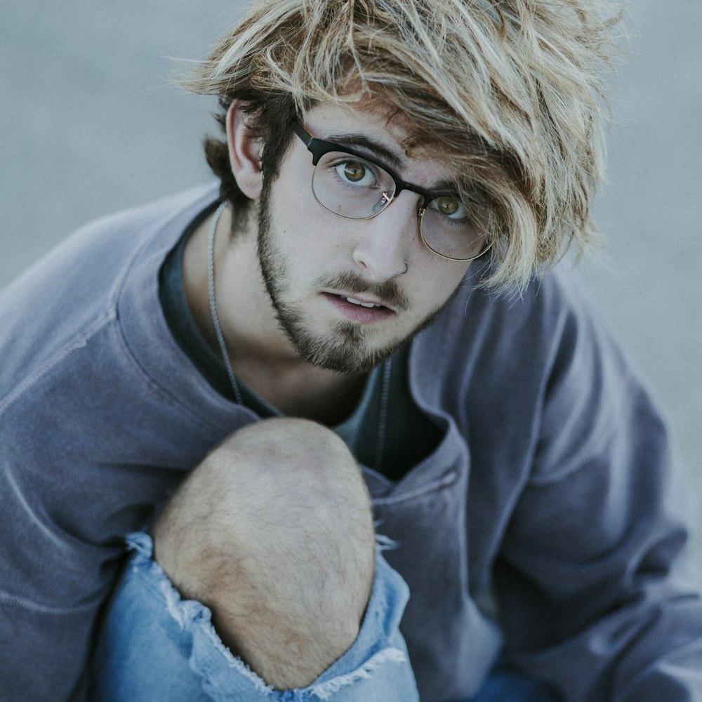 um jovem com um corte de cabelo bagunçado e óculos