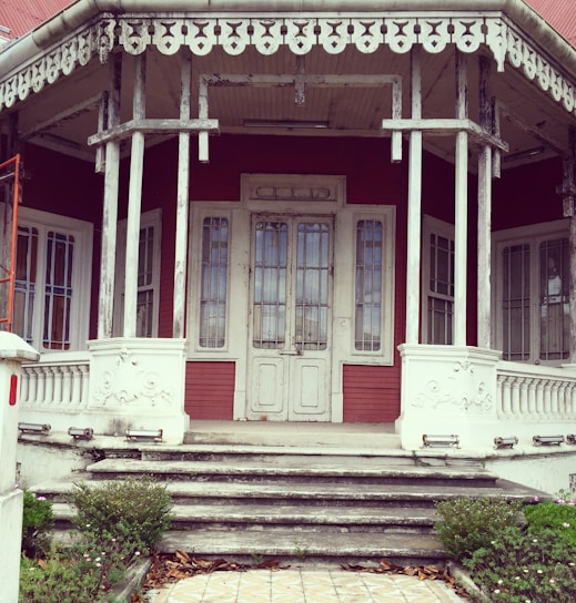 A cozy front porch featuring a beautifully crafted wooden door with intricate glass panels.