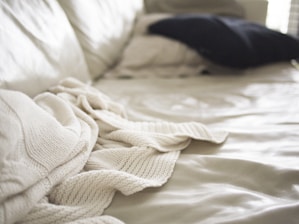 Close-up of a cozy bed dressed in soft, brushed fabric bedding with delicate stitching details.