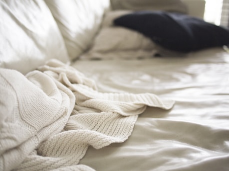Photo of a cozy single mattress with a simple cream background.