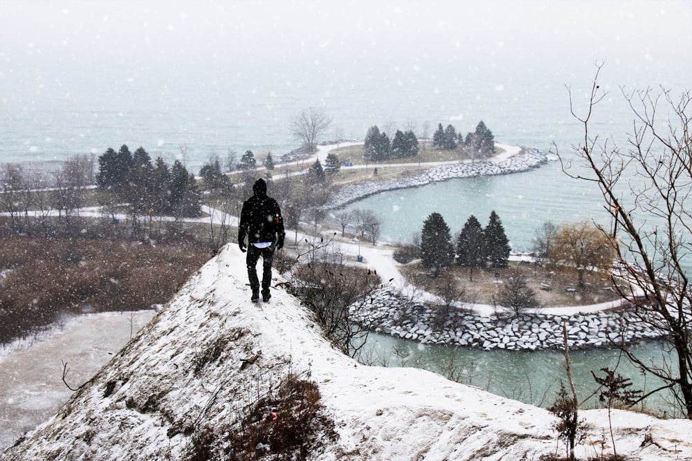 pessoa em pé na montanha revestida com neve