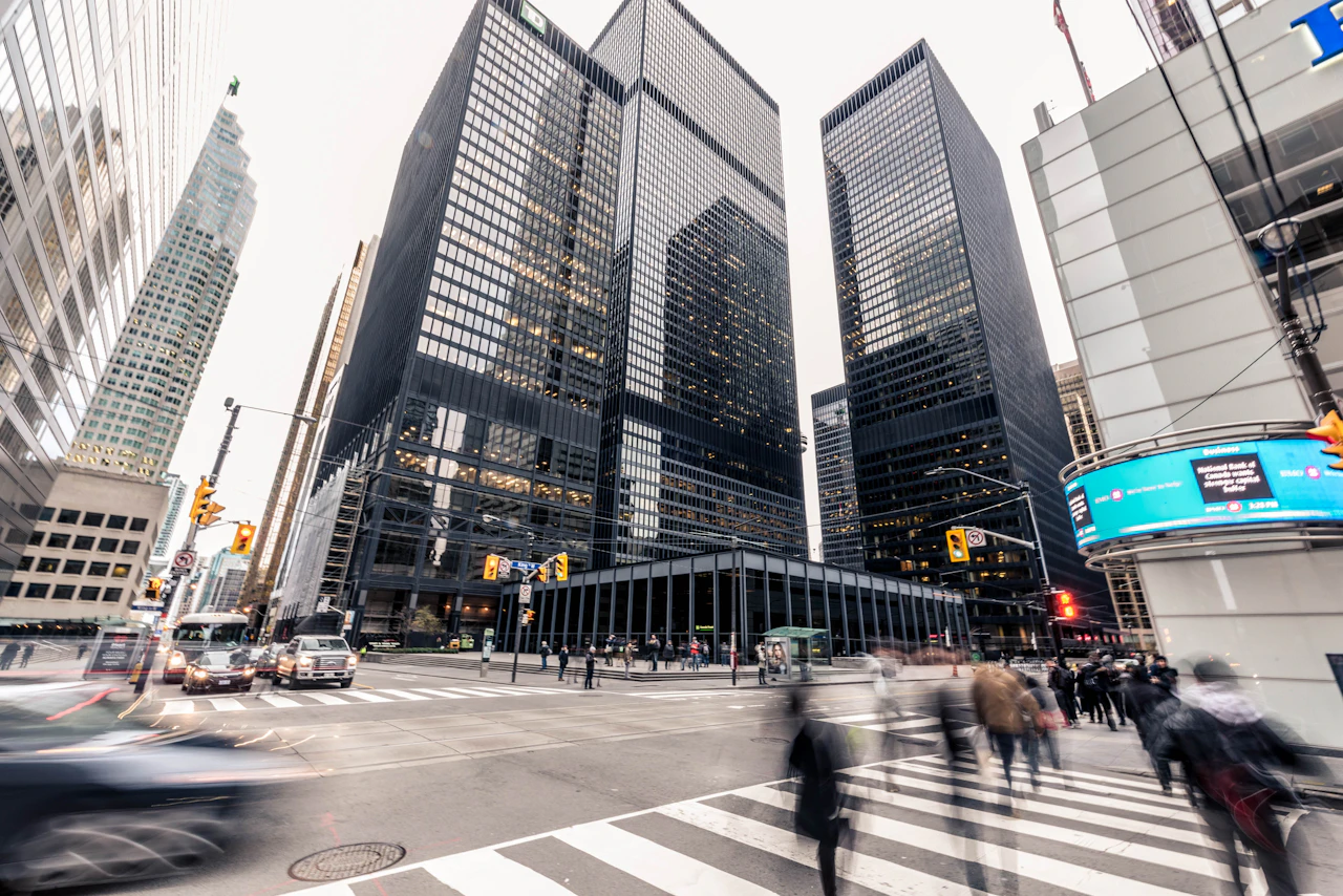 People crossing in front of high-rise office buildings in a financial district