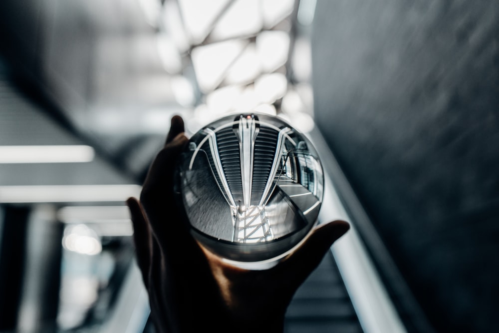 person holding clear glass decor