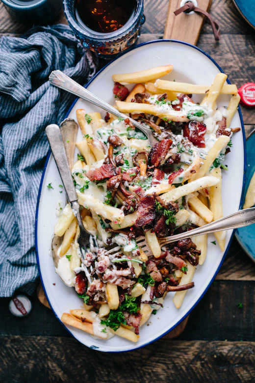 A tray of loaded fries smothered in cheese sauce and toppings