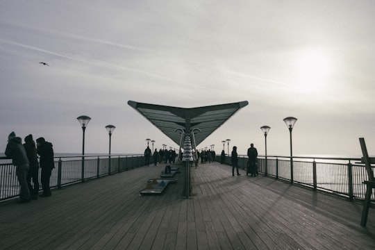 people on wooden dock with lampposts during day in Boscombe United Kingdom