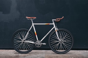 gray fixie bike leaning on black wall