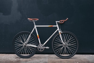 gray fixie bike leaning on black wall
