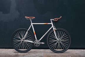 gray fixie bike leaning on black wall