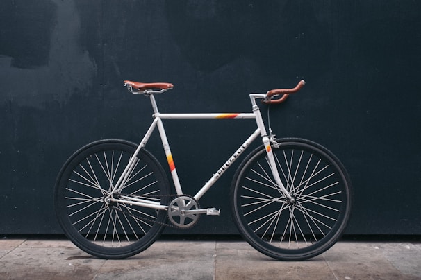 Side view of a retro-inspired bicycle with sleek dark anthracite paint and off-white leather saddle