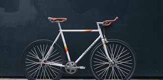 gray fixie bike leaning on black wall