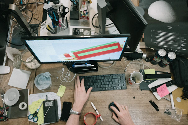 A busy office desk with organized stationery and a computer, illustrating office supplies.