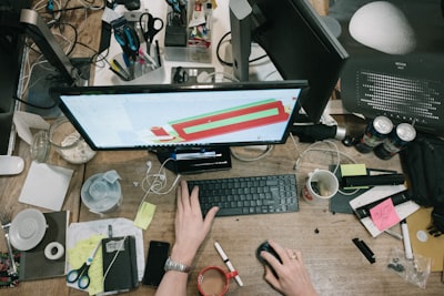 person using computer on brown wooden table busy teams background