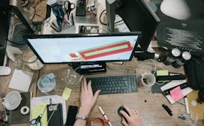 person using computer on brown wooden table