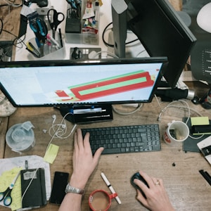 person using computer on brown wooden table