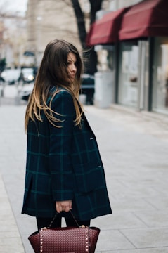 woman holding brown leather bag in bokeh photography