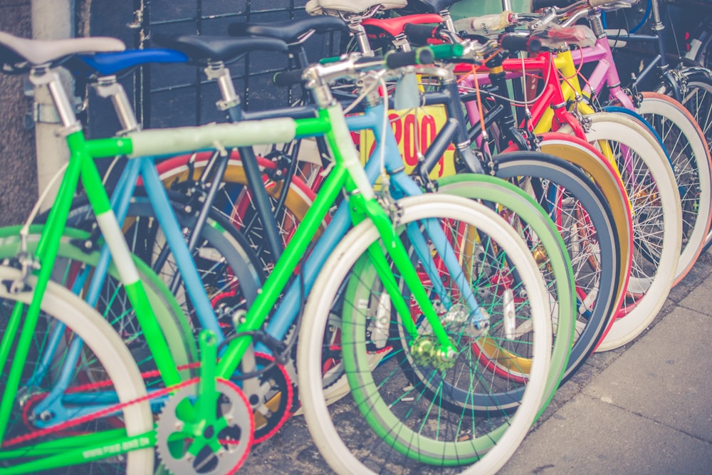 photo of assorted-color bicycles on gray pavement
