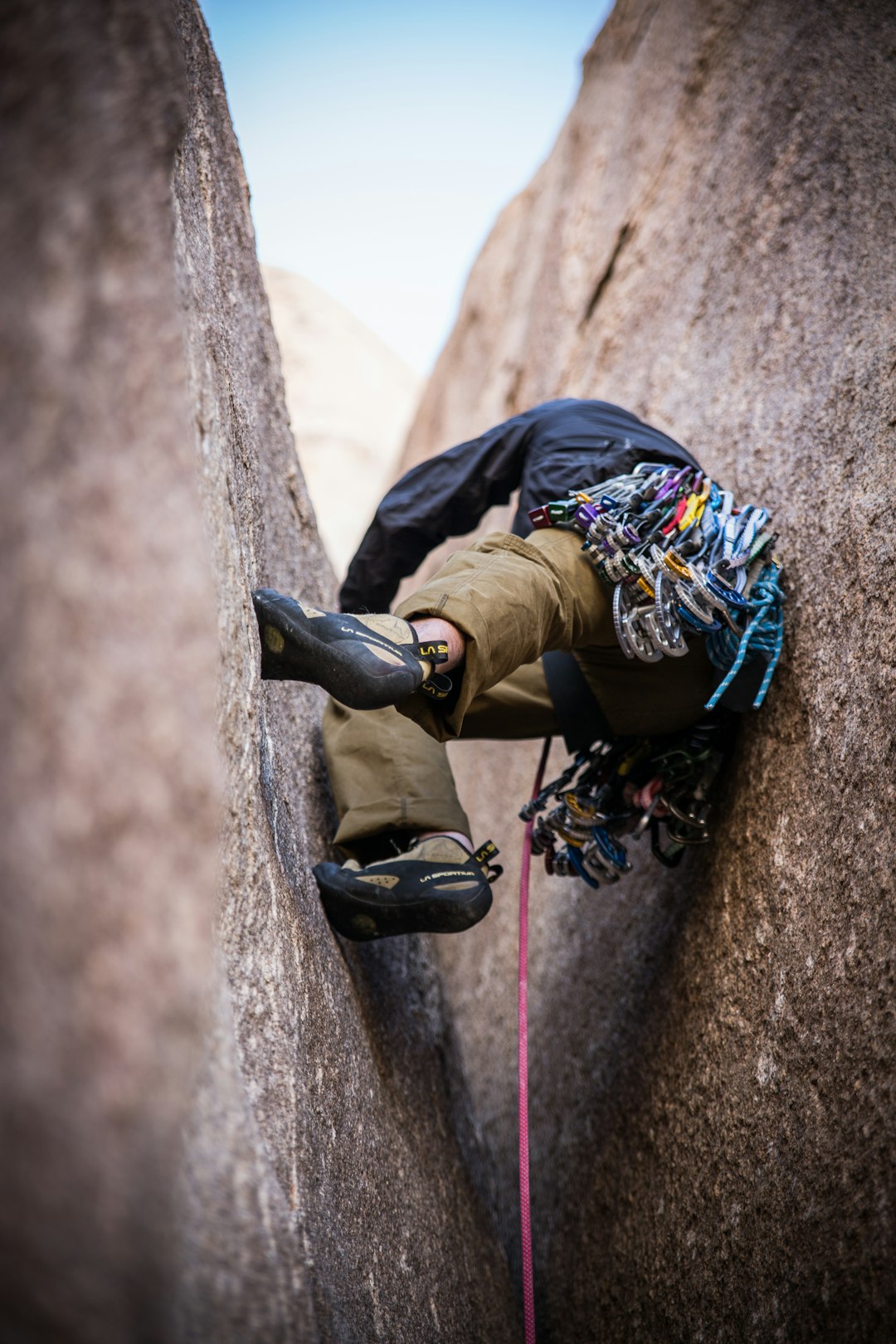 person climbing between cliff during daytime