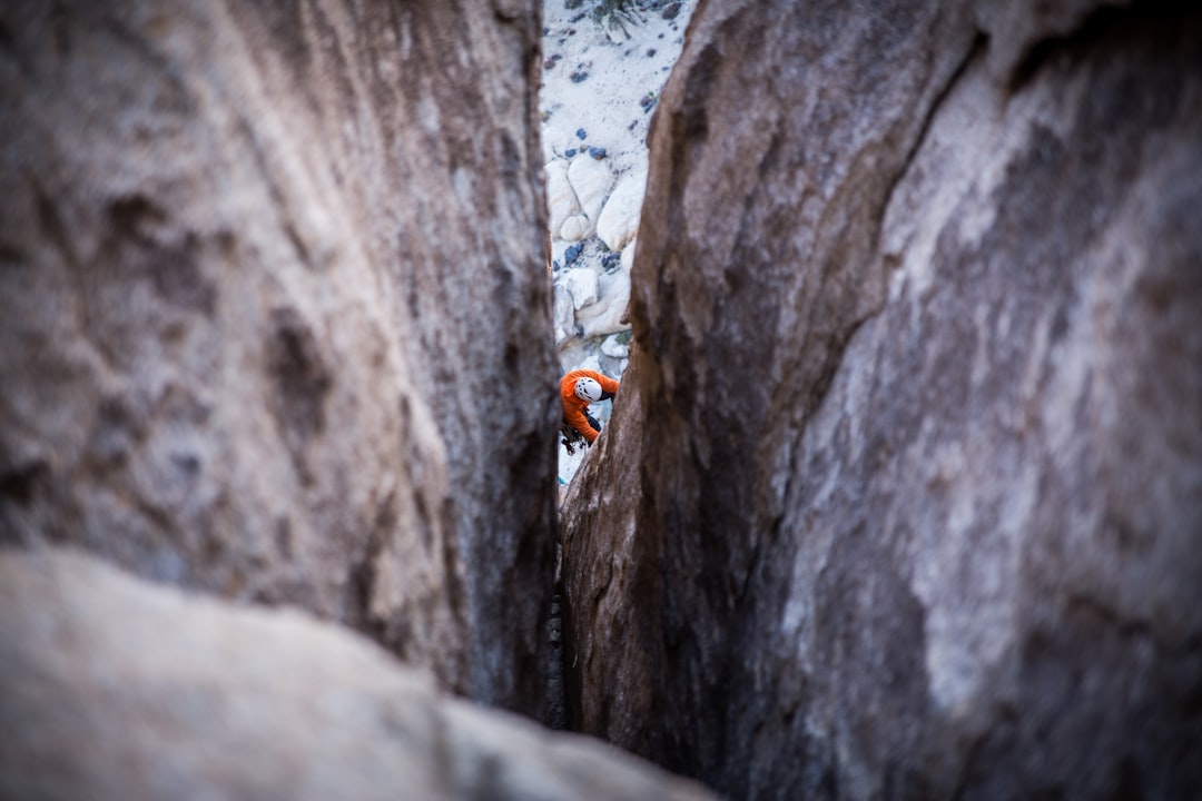 person climbing on rock during daytime