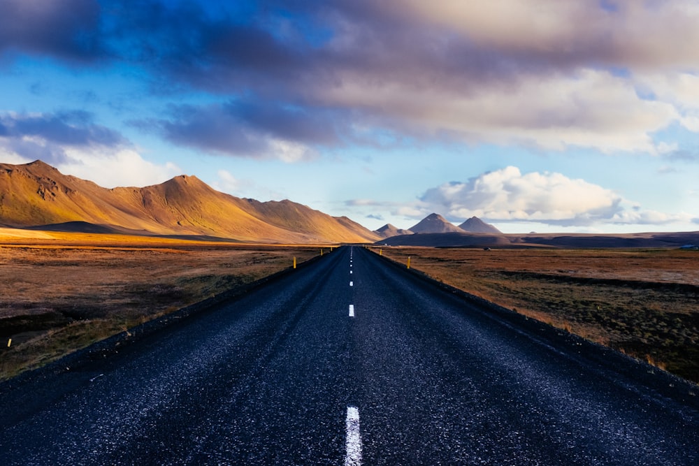 black concrete road with distance to mountains