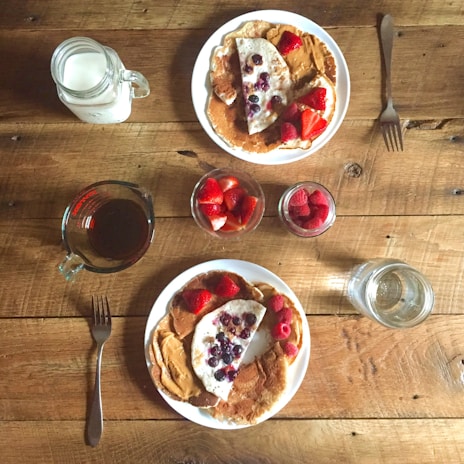 A rustic wooden table displaying various syrup bottles.