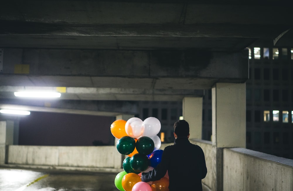 homem segurando o lote do balão durante a noite