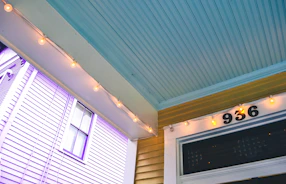 A friendly property manager speaking with a happy renter at a sunny front porch.