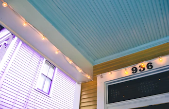 A friendly property manager speaking with a happy renter at a sunny front porch.