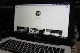 A close-up of a laptop screen showing a LinkedIn profile page with a professional photo.