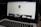 A laptop displaying a social media profile page with various elements such as a profile picture, username, and links. Below the main header, there are sections for photos and collections, showing preview images. The laptop keyboard is visible in the lower part of the image.