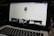 A laptop displaying a social media profile page with various elements such as a profile picture, username, and links. Below the main header, there are sections for photos and collections, showing preview images. The laptop keyboard is visible in the lower part of the image.