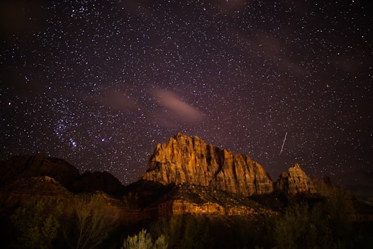 brown rocky mountain near body of water at night in Zion National Park United States