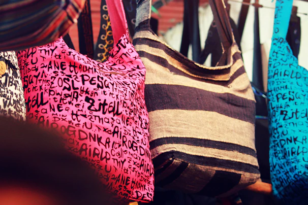 Upcycled fabric bags hanging on hooks, showcasing vibrant patterns and textures