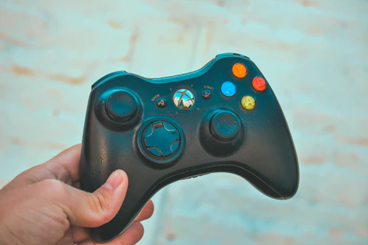 A dynamic gamer holding a controller with colorful game graphics in the background.
