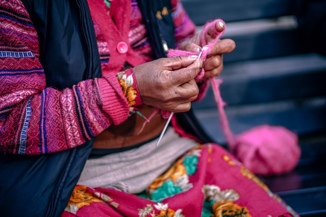 Woman knitting with pink yarn