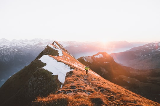A person walking on a rocky path along the mountain ridge in Augstmatthorn Switzerland