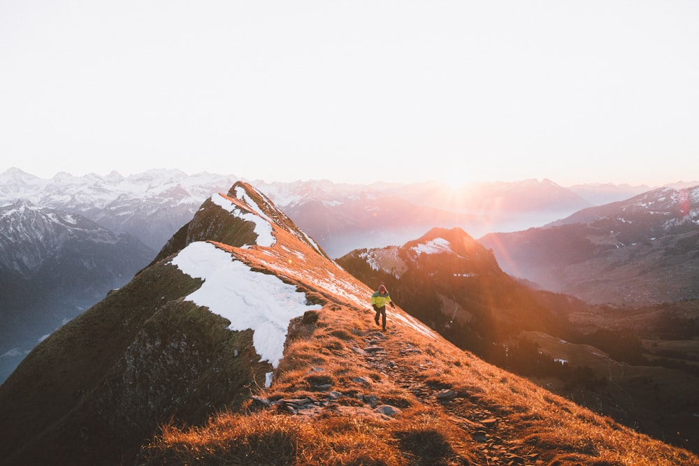 A person walking on a rocky path along the mountain ridge