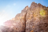 Rock climbers scaling a rugged cliff face with panoramic views of the valley below.