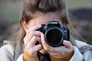 A friendly photographer holding a camera, ready to capture a moment.