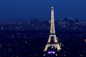 A breathtaking aerial view of the Eiffel Tower glowing at sunset with Paris cityscape in the background.
