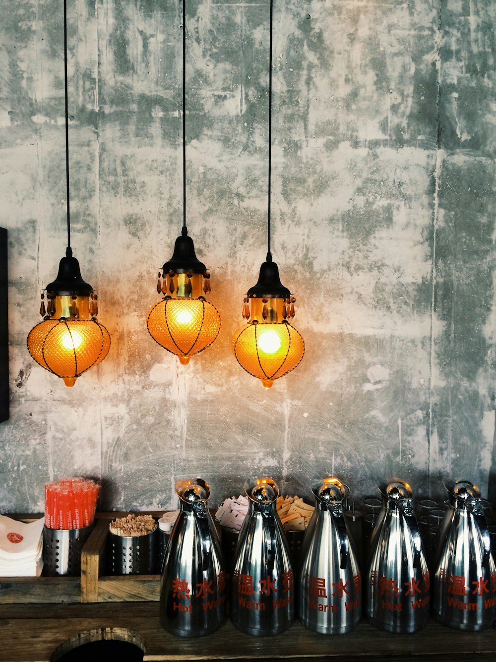 three brown pendant lamps near wall