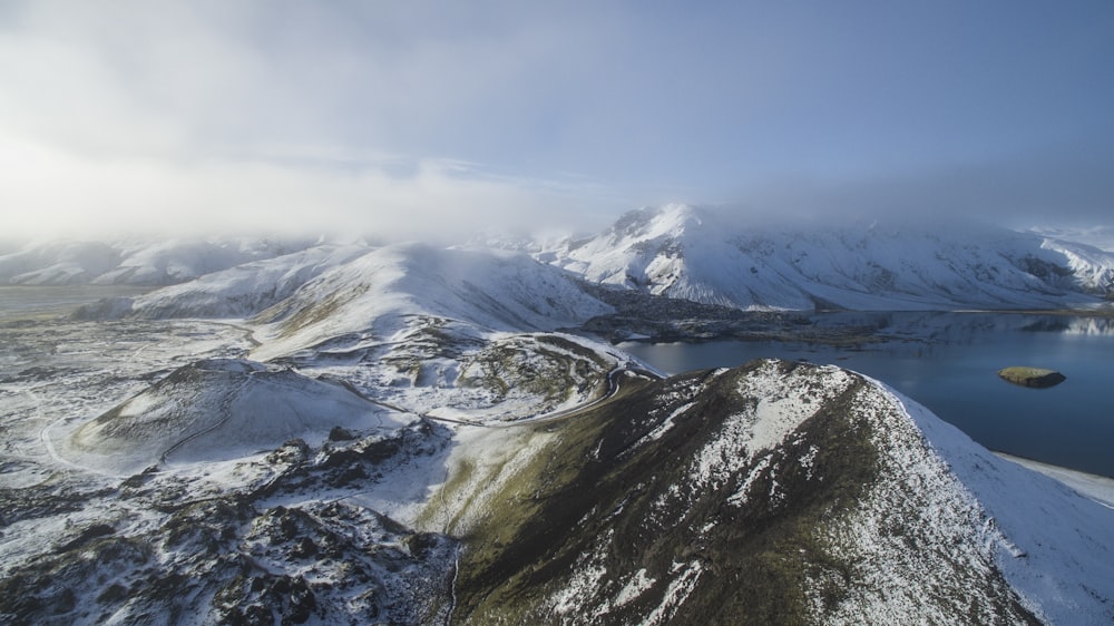 Photographie de vue aérienne de la montagne enneigée près du lac