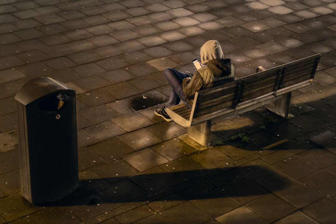 person sitting on outdoor bench during daytime