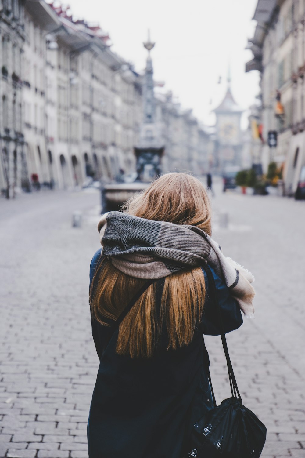 woman standing on sidewalk during daytime