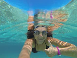 Smiling instructor demonstrating swim techniques to attentive swimmers.