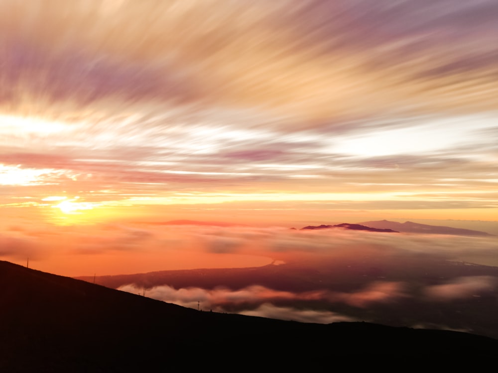 Foto da silhueta da montanha sob o céu alaranjado