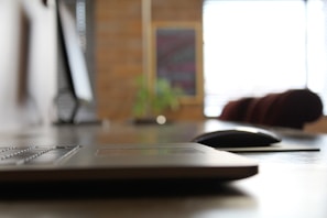 A person typing on a laptop with a blurred background of a home office