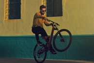 man riding bicycle doing tricks near building photography