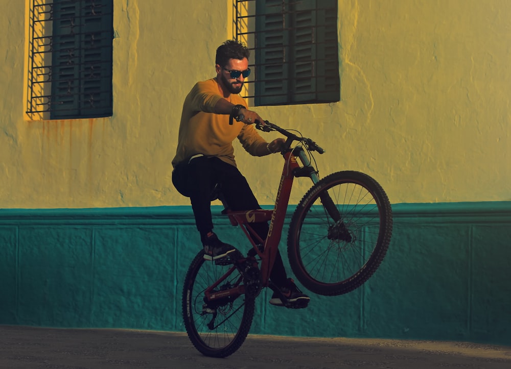 homem andando de bicicleta fazendo truques perto da fotografia do edifício
