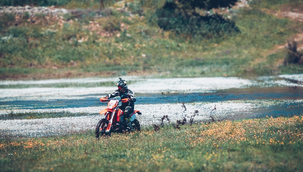 man riding motorcycle on body of water